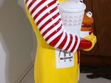 statue of a clown holding a plate of food in a room