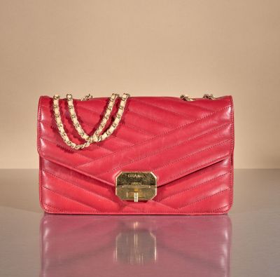 pink purse with chain strap and clasp on a shiny surface