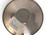 a metal bowl with a label on it and a piece of paper in it