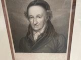 a framed picture of a man in a black coat