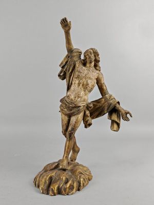 a bronze statue of a man holding a hat on top of a rock