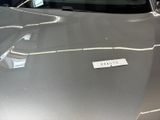 a shiny silver car with a sticker on it ' s hood