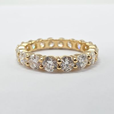 un gros plan d'une bague en or jaune sertie de cinq diamants ronds