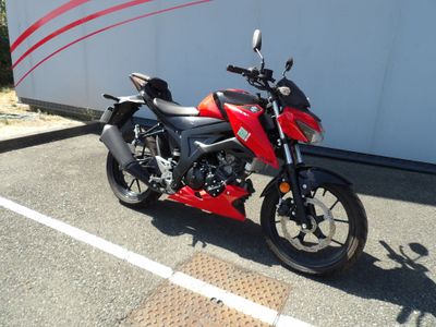 une moto rouge et noire garée sur un parking