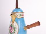 a blue and gold coffee pot with a wooden handle