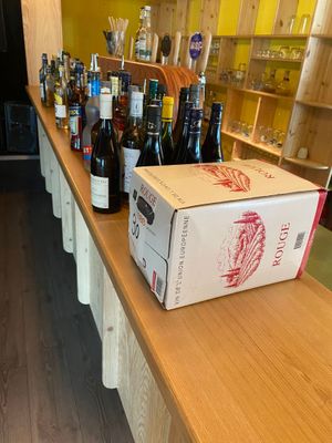 bottles of wine are lined up on a counter in a wine shop