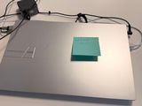 un ordinateur portable posé sur une table, avec des câbles branchés dessus