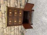 a small wooden cabinet with a door open on the side of a stone wall