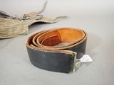 a belt that is sitting on the floor next to a purse