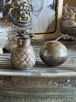 a silver statue of a lion on a table next to an apple