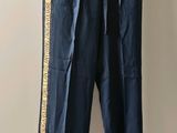 blue pants hanging on a hanger in a room with a white wall