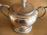 a silver teapot on a table with a price tag