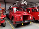 two red fire trucks parked in a garage