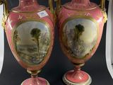 une paire de vases roses et dorés ornés d'une peinture représentant un paysage