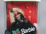 barbie doll in a plastic box with a black dress and a red berry