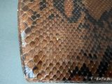 a close up of a snake skin purse on a table