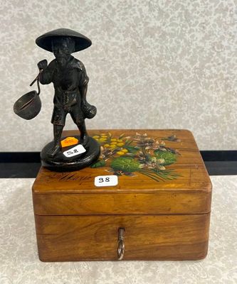 une petite boîte en bois sur laquelle trône une figurine