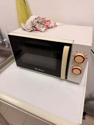 a microwave on top of a washing machine in a kitchen