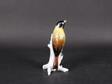 a figurine of a bird sitting on top of a branch