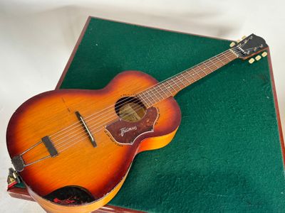 une image représentant une guitare posée sur une boîte verte
