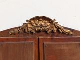 a wooden cabinet with a gold leaf decoration on top of it