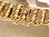 a close up of a gold bracelet with a chain on it