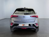 the rear end of a silver car in a white room