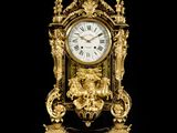 a gold clock sitting on top of a marble table