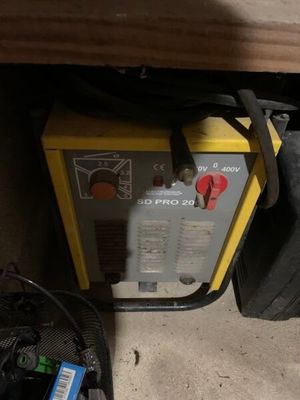 une machine jaune et noire posée par terre à côté d'un sac noir