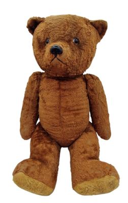 a brown teddy bear that is sitting on a white surface
