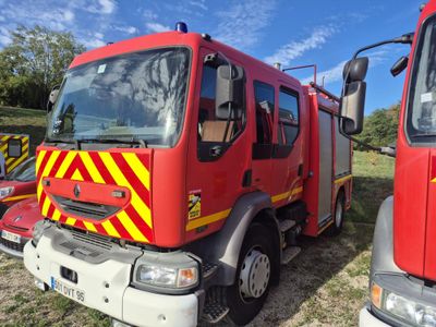 two fire trucks parked next to each other in a field