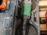 a green and orange drill on a pallet