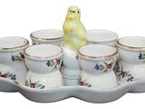 a tray with cups and a bird figurine on it