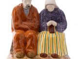 a figurine of two people sitting on a bench