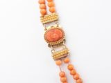 a close up of an orange beaded necklace on a white surface