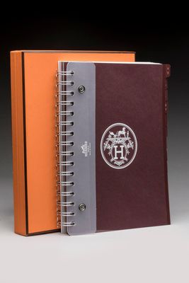 an orange and grey notebook with a logo on the cover