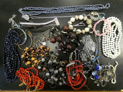 many different types of necklaces and bracelets laid out on a table