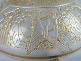 a white and gold vase with gold designs on it