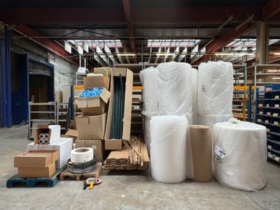 de nombreux rouleaux de papier blanc posés par terre dans un entrepôt