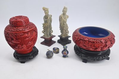 trois vases rouges posés les uns à côté des autres sur une table