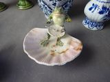 a figurine of a frog sitting on a shell