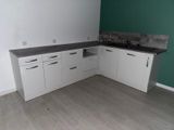 a kitchen with white cabinets and a black counter top