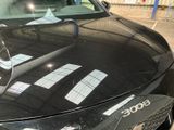 a black car parked in a parking lot next to a building