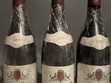 three bottles of wine are lined up on a shelf