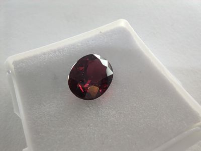 un gros plan d'un diamant rouge sur une surface blanche