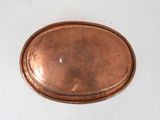 an old copper plate on a white table with a white background