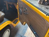 a yellow car with a door open on the side of the road
