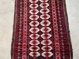 a red and black rug with a diamond design on it