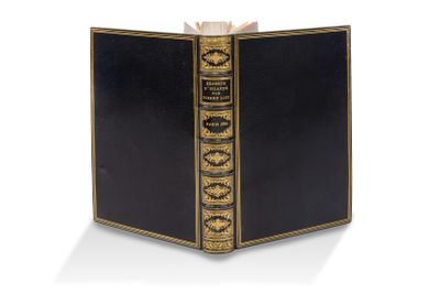 un vieux livre à la couverture noire, rehaussée de dorures sur fond blanc