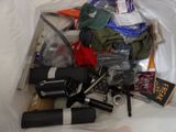 a bag full of assorted items sitting on a bed